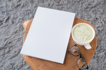 blank magazine mockup on coffee table with green matcha tea near window