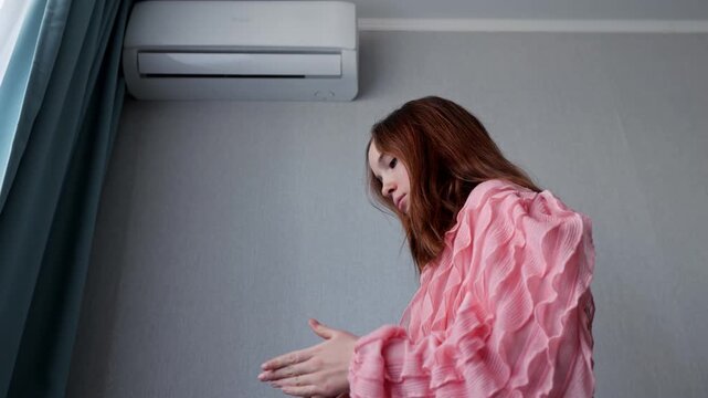 Woman trying to turn on broken air conditioner