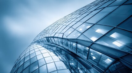 Modern architecture featuring a curved glass facade, reflecting sky and light, emphasizing design and innovation in urban development
