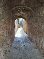 narrow street in the old town of volterra, tuscany, italy