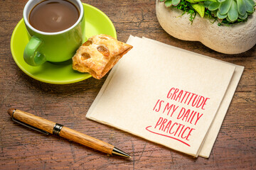 gratitude is daily practice - inspirational positive affirmation note on a napkin with coffee