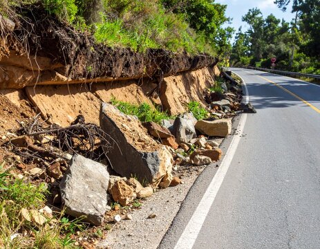 Carretera rural bloqueada por un derrumbe reciente de tierra y piedras, con vegetaci&oacute;n da&ntilde;ada