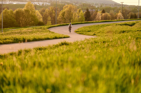 A lone cyclist rides along a winding path 