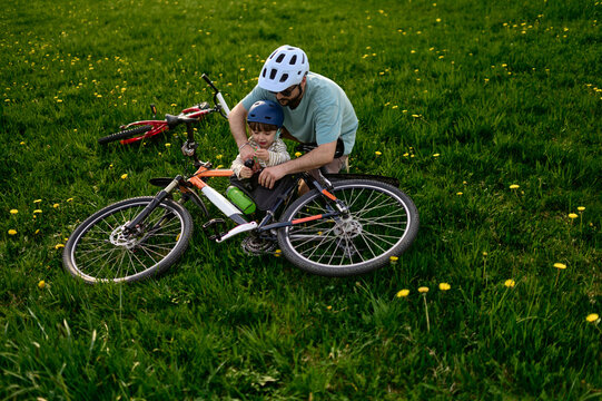 A father and his child explore a bike components