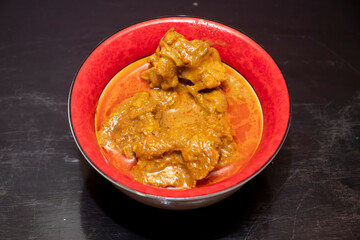 Traditional Beef Rezala gravy in Red Bowl top view of Authentic Bengali Mughlai Cuisine