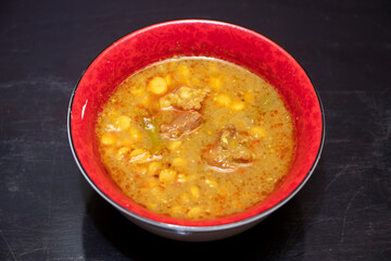 Mezbani Dal with Beef, A Traditional Bengali Lentil Curry with Meat Served in Red Bowl on Dark Background top view