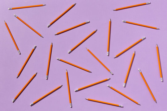 Orange pencils on violet background
