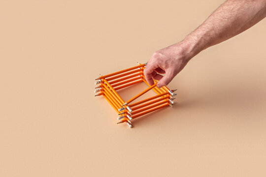 Hand building stacked square shape with pencils