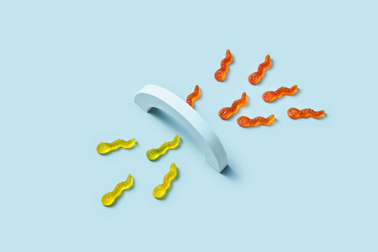 Yellow and orange gummy worms divided by arch