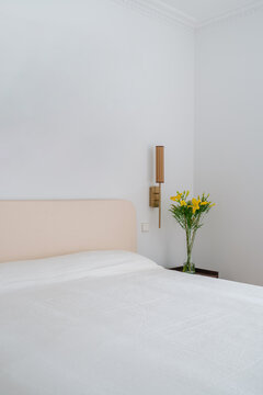 Close-up of bed corner with yellow flowers and abstract art
