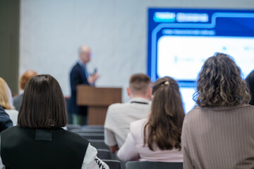 Attendees listening to a speaker during a professional event focusing on knowledge sharing.