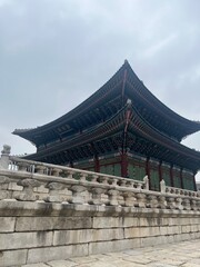 Fototapeta premium Traditional Korean Palace Pavilion with Ornate Roof and Stone Terrace