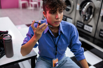 Woman working on phone at laundromat