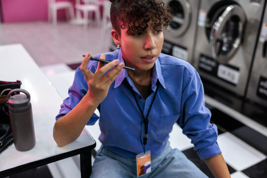 Woman working on phone at laundromat