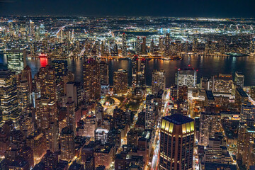 Fototapeta premium View to the New York City downtown of Manhattan during night life and with the Empire State Building at the background