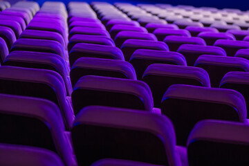 Naklejka premium Empty theater seating brightly lit with purple lights creating a captivating visual appeal