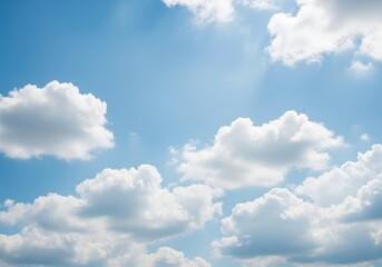 Obraz premium Bright blue sky with fluffy white clouds on a sunny day, creating a serene and peaceful atmosphere