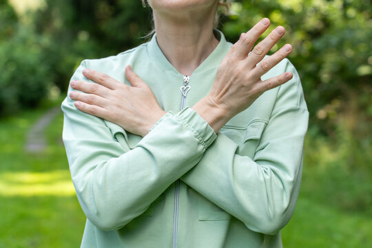 Woman Practices Self-therapy by Tapping her Shoulders with her Arms Crossed Over her Body While Practicing EMDR in a Quiet Outdoor Setting