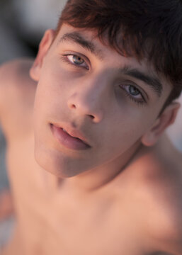 Teenage boy looking up with hope and serenity in the golden hour light.