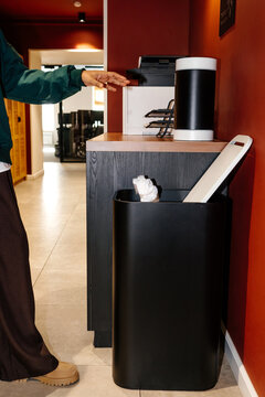 Hand tossing crumpled paper into office trash bin