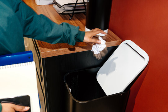 Throwing crumpled paper into office trash bin