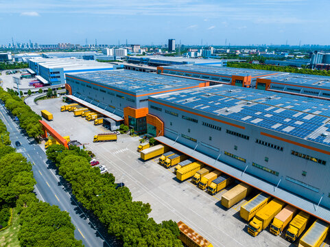 Aerial View of Factory with Solar Panels and Transport Trucks