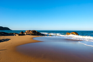 Rochas em praia com lindo céu azul