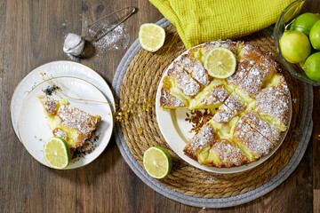 Delicious Lime Cake with Powdered Sugar Topping and Fresh Limes Display