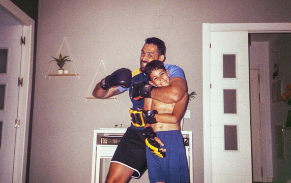 35mm film image of father boxing playfully with son at home