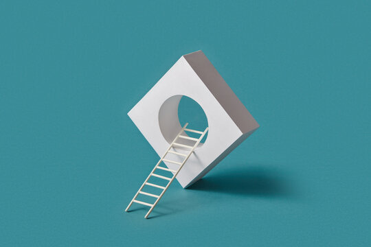 Paper ladder entering tilted white square on teal base
