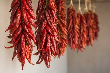 Obraz premium Strings of dried red chili peppers hanging as a decorative and flavorful ingredient for cooking and seasoning food
