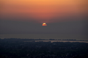 hazy misty sunset in orange and red over Lake Constance seen from high up in Bildstein, Vorarlberg ,Austria