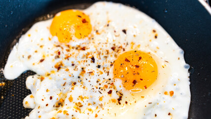 Golden fried eggs with fresh farm herbs, perfectly seasoned and rustic. Appetizing breakfast photography for chefs, food blogs, and organic farm marketing