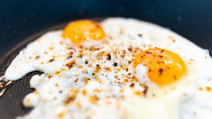 Golden fried eggs with fresh farm herbs, perfectly seasoned and rustic. Appetizing breakfast photography for chefs, food blogs, and organic farm marketing