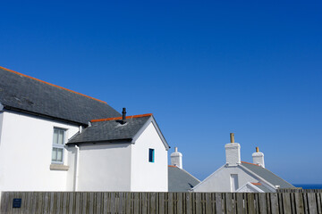 Freshly painted white farm house building beside the seasise on a blue sky sunny day