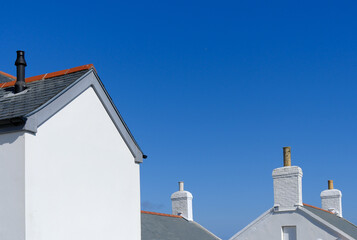 Freshly painted white farm house building beside the seasise on a blue sky sunny day