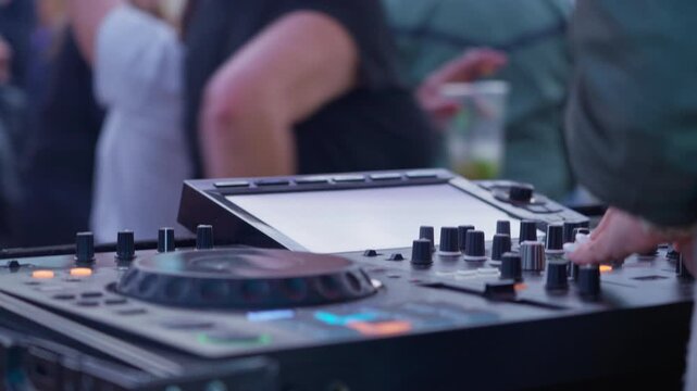 Female dj switching tracks with colorful bokeh