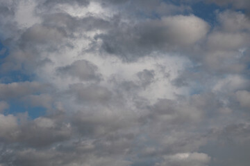 Dramatic Background Of A Sky Filled With Grey And White Overcast Clouds, With Patches Of Blue. Natural Weather Texture.