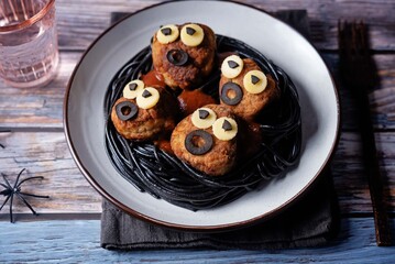Meatballs with black pasta in the plate for Halloween
