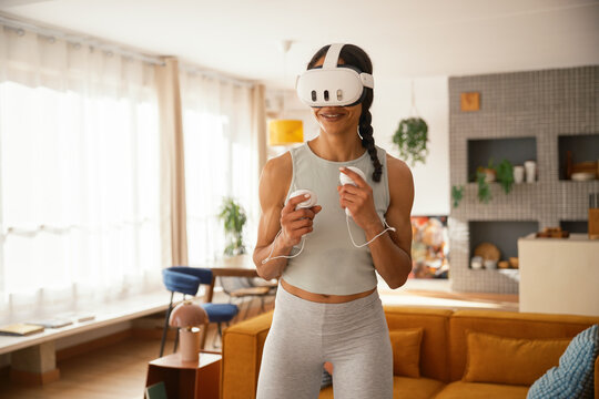 Woman doing fitness with VR glasses at home