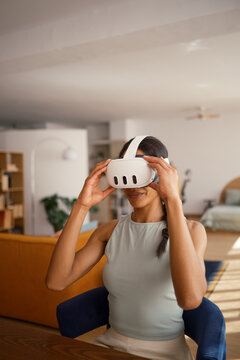 Woman putting on VR glasses at home