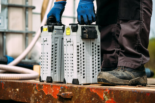 Worker Carrying Two Agricultural Drone Battery Packs