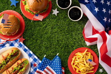Festive picnic setup celebrating Labor Day and Independence Day with burgers, hot dogs, fries, and American flag decorations on a grassy setting