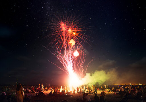 Summer fireworks night at crowded beach
