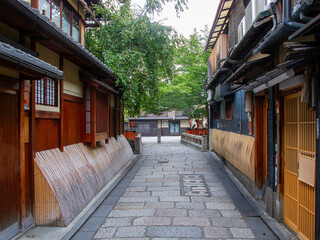 Fototapeta premium 京都の有名観光地の祇園の切通しの通りから見える京町家と祇園白川に架かる巽橋の無人の風景
