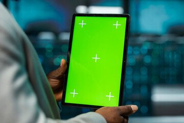 Close up of data center engineer using isolated screen tablet, managing rackmounts energy consumption. Worker using chroma key device used for automation and monitoring processes in server room