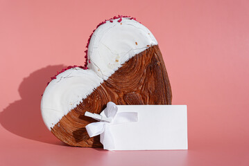 Empty template paper note mockup Heart shaped white chocolate croissant on pink background with copy space. Puff pastry new trendy sweet dessert bakery. Creamy dough experiment 