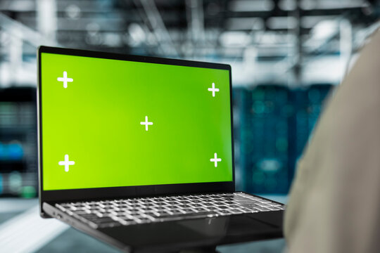 Close up of server hub engineer using mockup laptop to repair equipment storing datasets. IT professional using green screen notebook to do debugging on rigs doing computational operations