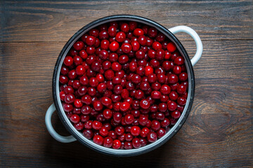 Fresh red cherries piled high showcasing the bounty of summer harvest. Glossy cherries arranged in saucepan. Juicy cherry symbolizing the sweetness and richness of life, closeup