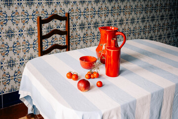Bright Red Pottery and Fresh Produce on Striped Tablecloth